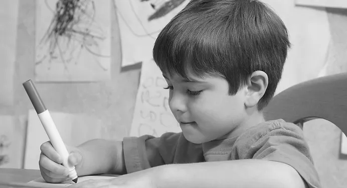 Niño escribiendo en su cuaderno