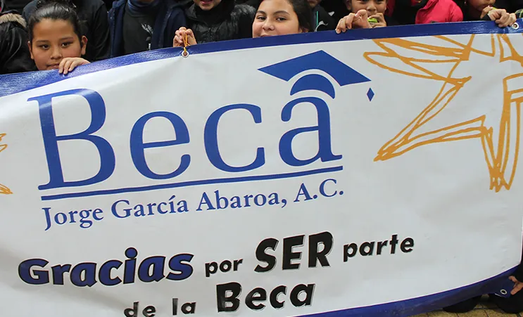 Niños sosteniendo la lona “Gracias por ser parte de la Beca”