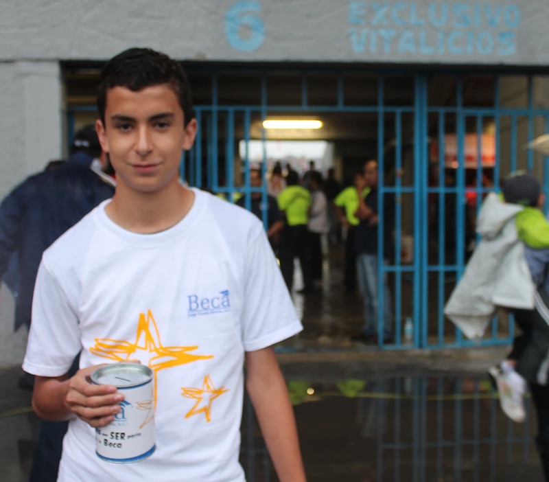 Alumno becado realizando el boteo afuera del estadio de Rayados
