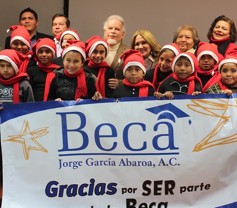 Niños de comunidades indígenas con la lona de la Beca